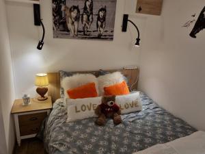 a teddy bear sitting on a bed with pillows at Studio Cabine F4 en Station Ski - 200m des Pistes - FR-1-687-118 in Flaine