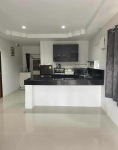 a large kitchen with a counter top in a room at Phimpakan guesthouse in Nakhon Phanom