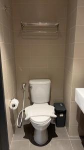 ein Badezimmer mit einer weißen Toilette und einem Waschbecken in der Unterkunft Utopia Central in Ban Nong Chaeng