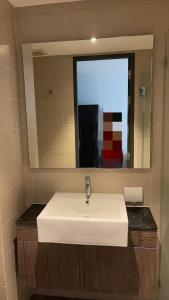 ein Badezimmer mit einem weißen Waschbecken und einem Spiegel in der Unterkunft Utopia Central in Ban Nong Chaeng