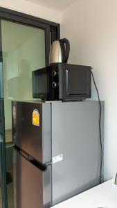 eine Mikrowelle auf einem Kühlschrank in der Unterkunft Utopia Central in Ban Nong Chaeng