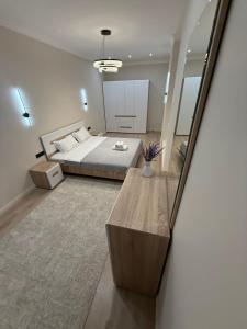 ein großes Schlafzimmer mit einem Bett und einem Tisch in der Unterkunft ЖК Кристалл 160К7 15 этаж 846 in Almaty