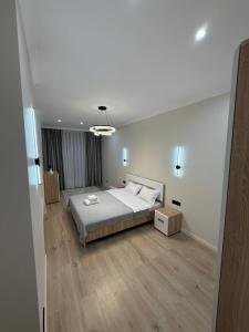 ein Schlafzimmer mit großem Bett und Holzboden in der Unterkunft ЖК Кристалл 160К7 15 этаж 846 in Almaty