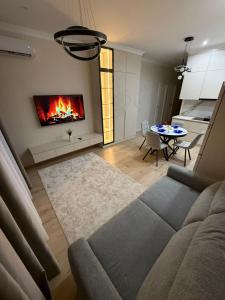 ein Wohnzimmer mit Couch und Kamin in der Unterkunft ЖК Кристалл 160К7 15 этаж 846 in Almaty