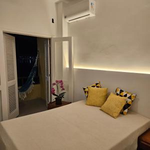 ein Schlafzimmer mit einem Bett mit gelben Kissen in der Unterkunft Condomínio Cabo Frio in Cabo Frio + 36 Fotos