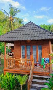 a wooden cabin with a porch and stairs to it at Yellow Coco Gili Gede in Gili Gede