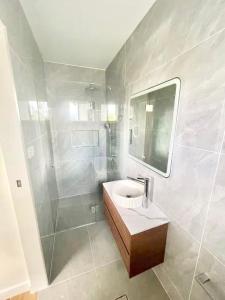 een badkamer met wastafel en douche bij Bedroom with Ensuite Near Train Station and Airport in Revesby