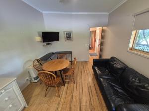 GellibrandにあるOtways Tourist Parkのテーブルとソファのあるリビングルーム