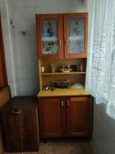 ein kleines Bad mit einem Waschbecken und Holzschränken in der Unterkunft Aconchegante apto em Capao da Canoa in Capão da Canoa