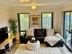 a living room with a couch and a coffee table at Glamorous Getaway in Mandurah