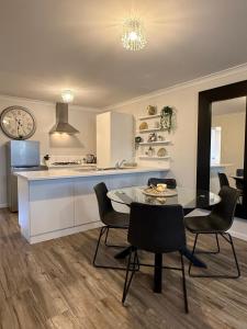 kuchnia i jadalnia ze stołem i krzesłami w obiekcie Glamorous Getaway w mieście Mandurah