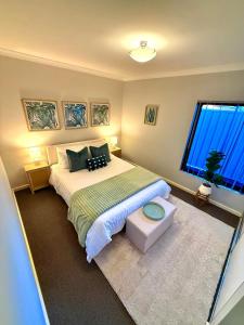 sypialnia z dużym łóżkiem i oknem w obiekcie Glamorous Getaway w mieście Mandurah +4 zdjęcia