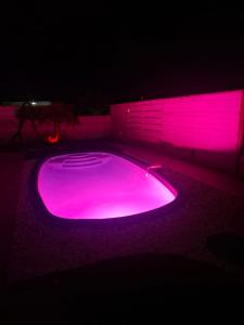 a pool with pink lights in the dark at Duplex Atypique et Authentique in Saint Martin