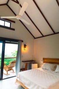 a bedroom with a bed and a ceiling fan at Ecohotel Summer Usiacuri in Usiacurí