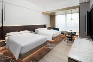 a hotel room with two beds and a desk at Renaissance Shenzhen Bay Hotel in Shenzhen