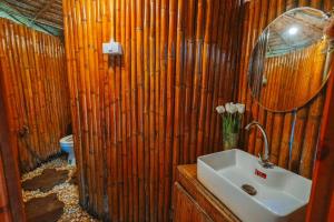 a bathroom with a sink and a wooden wall at ดานบนดินCamping in Ban Thung Phan Ha +41 photos
