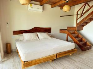 a bedroom with a bed with a wooden frame and stairs at Ecohotel Summer Usiacuri in Usiacurí +23 photos