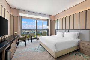 a hotel room with a bed and a television at Holiday Inn Shanghai Minhang Center by IHG in Shanghai