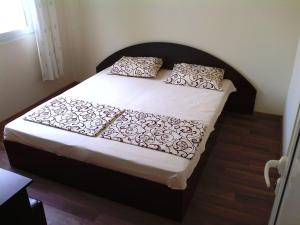 a bedroom with a bed with white sheets and pillows at Bungalows St. Nicola in Ahtopol