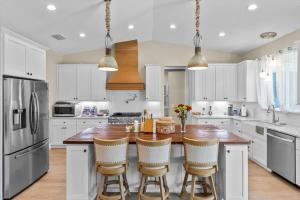 a kitchen with white cabinets and a wooden island with bar stools at Charming 3BR Waterfront Home - Private - Serene in Inverness