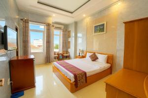 a hotel room with a bed and a television at Hồng Nhung Hotel Kiên Giang in Rạch Giá