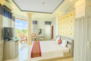ein Hotelzimmer mit einem Bett und einem Fernseher in der Unterkunft Hồng Nhung Hotel Kiên Giang in Rạch Giá