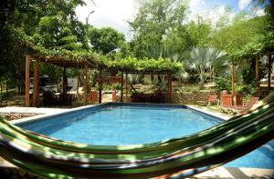 a hammock with a swimming pool in a yard at Ecohotel Summer Usiacuri in Usiacurí