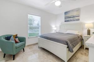 a bedroom with a bed and a green chair at Elegant 4BR Waterfront Retreat l Private Pool in Marco Island