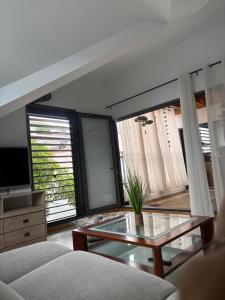 a living room with a glass table and some windows at Chambre Saint Gilles les bains1 in Saint-Paul