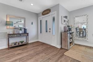 a living room with a door and a mirror at Inviting Lakeview Home l Pool l Close to Beaches in Marco Island
