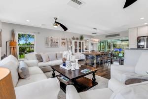 a living room with white furniture and a table at Inviting Lakeview Home l Pool l Close to Beaches in Marco Island