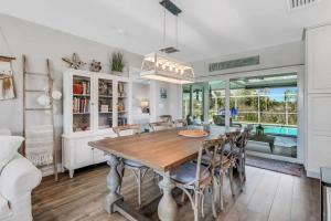 a dining room with a wooden table and chairs at Inviting Lakeview Home l Pool l Close to Beaches in Marco Island +25 photos