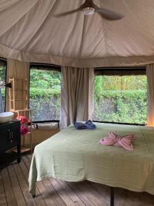 a bedroom with a bed with a pink bow on it at Safari tent with private pool close to Manuel Antonio Glamping 2 in Savegre