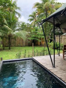 a small swimming pool with a wooden deck next to a yard at Safari tent with private pool close to Manuel Antonio Glamping 2 in Savegre