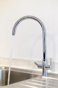 a water hose hanging from a kitchen sink at Stylish 1BR Apt near Cardiff Castle in Cardiff