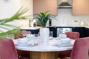 a table with plates and glasses and a plant on it at Stylish 1BR Apt near Cardiff Castle in Cardiff +30 photos