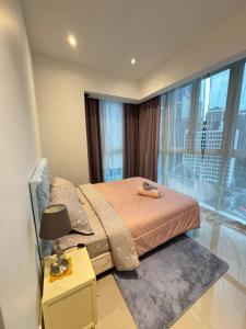 ein Schlafzimmer mit einem Bett und einem großen Fenster in der Unterkunft KLCC Marc Residence by AZ Line in Kuala Lumpur + 28 Fotos