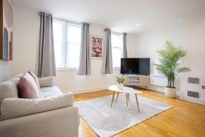a living room with a couch and a tv at Stylish 1BR Apt near Cardiff Castle in Cardiff