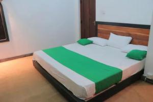 ein Schlafzimmer mit einem großen Bett mit grünen Kissen in der Unterkunft Cottage Purana in Bandarawela