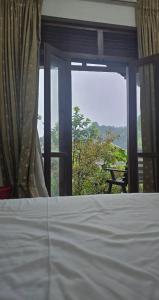 ein Schlafzimmer mit einem Bett und einem Fenster mit Aussicht in der Unterkunft Cottage Purana in Bandarawela
