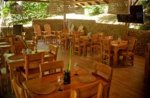 a restaurant with wooden tables and chairs at Ecohotel Summer Usiacuri in Usiacurí