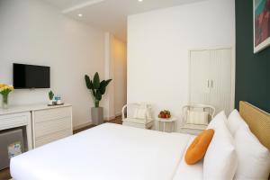 een slaapkamer met een wit bed en een tv bij Saigon Central Hotel in Ho Chi Minh-stad