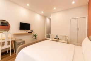 een slaapkamer met een bed, een bureau en een tv bij Saigon Central Hotel in Ho Chi Minh-stad