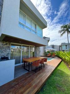 a wooden deck with a table and chairs on a house at MHV Milagres - Naluum G04, Casa em condomínio beira mar de alto padrão, a poucos metros da Capela dos Milagres in Passo de Camarajibe +87 photos