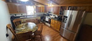 a kitchen with a table and a stainless steel refrigerator at Downtown Dog Friendly House in Fargo