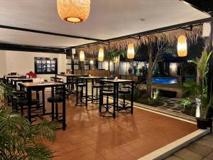 a restaurant with tables and chairs and plants at Abode Boutique Resort - Hua Hin in Hua Hin