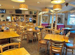 a restaurant filled with wooden tables and chairs at The Rainbow's nest in Morecambe