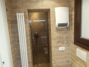 een douche met een glazen deur in een badkamer bij Cocoloco in Venetië +8 foto's