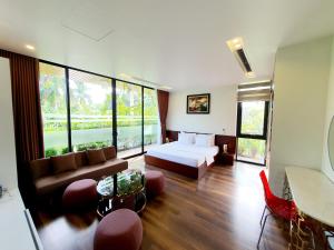 a living room with a bed and a couch at FLAMIGO Đại Lải - Villa Tự Doanh in Phúc Yên +139 photos