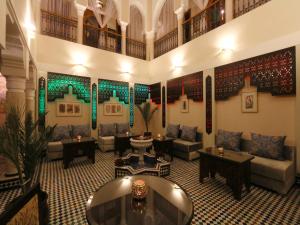 una sala de estar con sofás y mesas en un edificio en Riad Zaki, en Marrakech